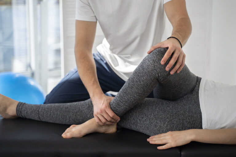 Fizjoterapeuta pomagający pacjentowi w prawidłowym rozciągnięciu mięśni